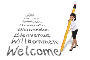 Businesswoman writing the word Welcome in various European languages with a giant pencil, isolated on a white background.